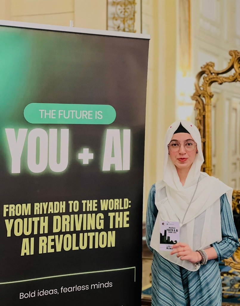 Maryam Siddiqui at the Youth & AI Summit, Riyadh, beside the event banner